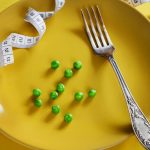 Diet yellow plate with centimeter peas and fork